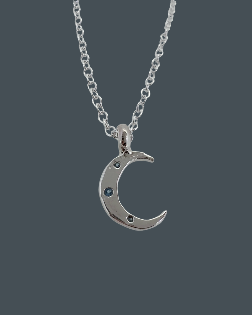 Silver crescent moon necklace with aquamarine trio, symbolic celestial jewellery in recycled sterling silver.