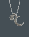 Close-up showing the sterling silver crescent moon necklace with a 5mm moonstone charm.