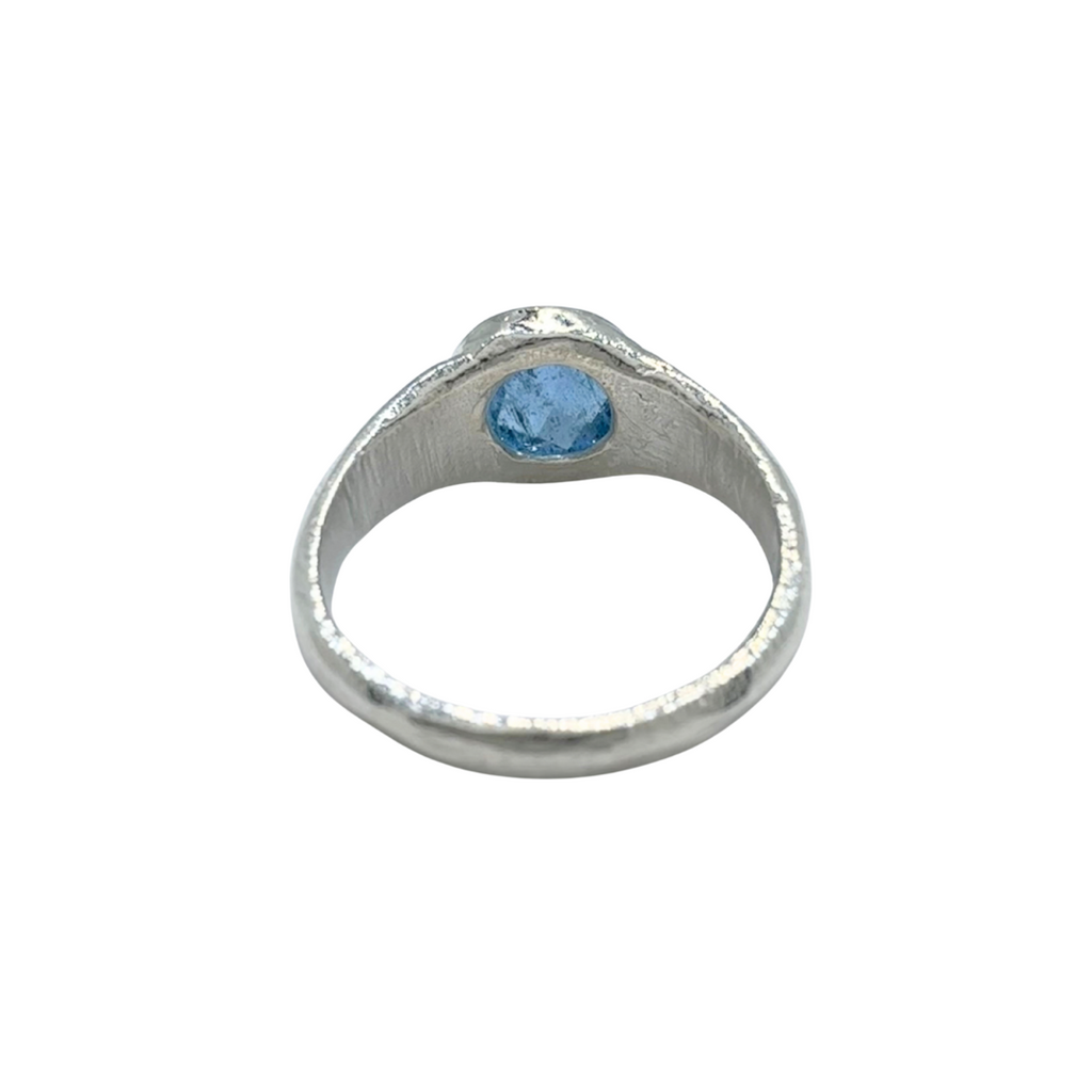 Back view of a sterling silver aquamarine signet ring with natural gemstone details on a white background.