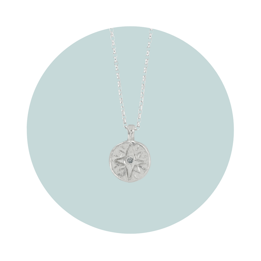 Recycled silver North Star pendant necklace with aquamarine March birthstone, flush set to symbolise calm and clarity.