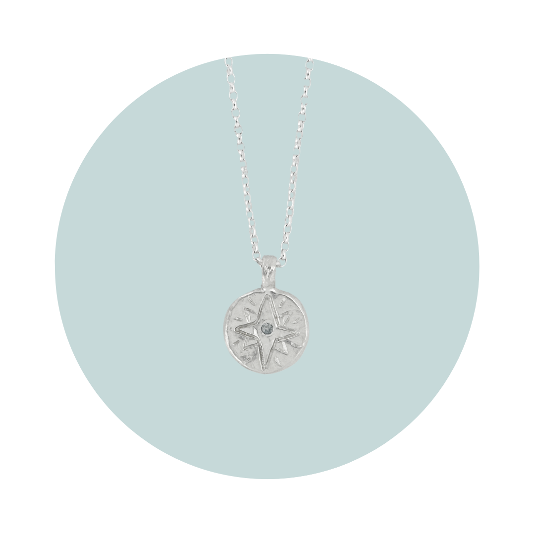 Recycled silver North Star pendant necklace with aquamarine March birthstone, flush set to symbolise calm and clarity.
