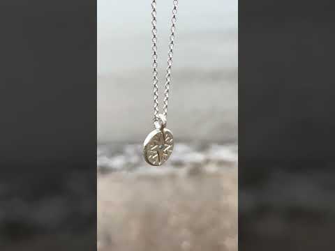 Recycled silver North Star necklace customised with aquamarine March birthstone, filmed by the sea to reflect its calm, clarifying energy.